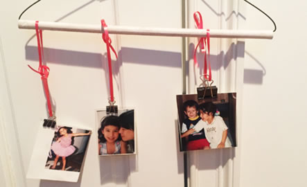 Photos hanging by a string on a clothes hanger.